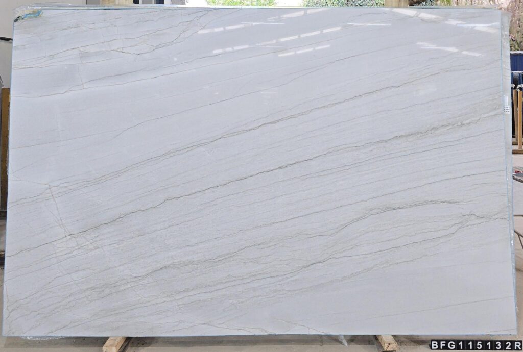 White Santorini Quartzite features a luminous ivory‑white base with elegant grey veining and subtle touches of caramel or gold. Its serene, versatile look pairs with both modern and traditional designs, while its true quartzite strength offers exceptional resistance to heat, scratching, and etching. A refined choice for luxury kitchens, waterfall islands, vanities, and bar tops.