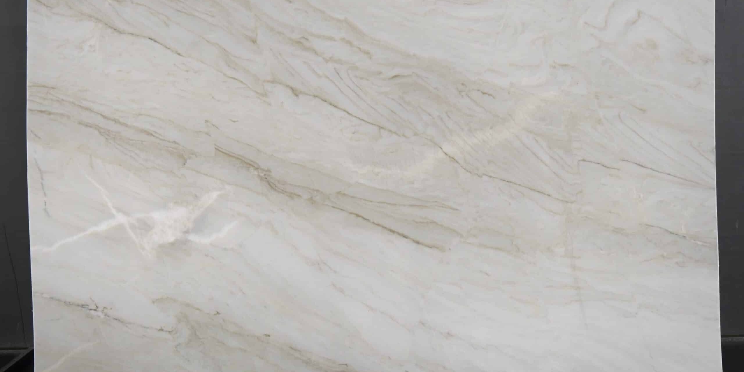 Full portrait of an authentic white quartzite slab inside a stone gallery warehouse highlighting its smooth, organic movement.