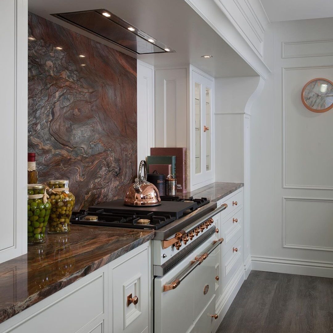 Contemporary kitchen island with a leathered quartzite countertop and dark wood cabinetry.