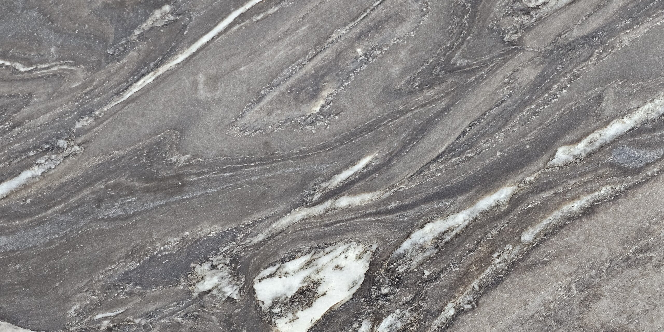 Focus on the sharp white highlights and fluid diagonal veining of the stone.