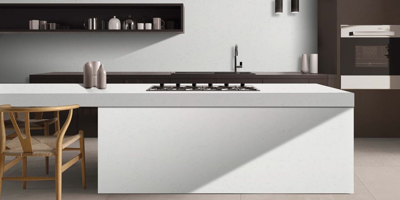 Bright kitchen interior with marble-look quartz countertops complementing neutral cabinets and stainless steel appliances.