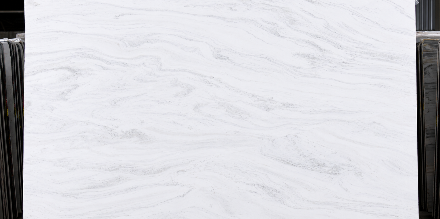Full view of an Olympus White slab showing its pristine white base and delicate, sweeping mineral patterns.