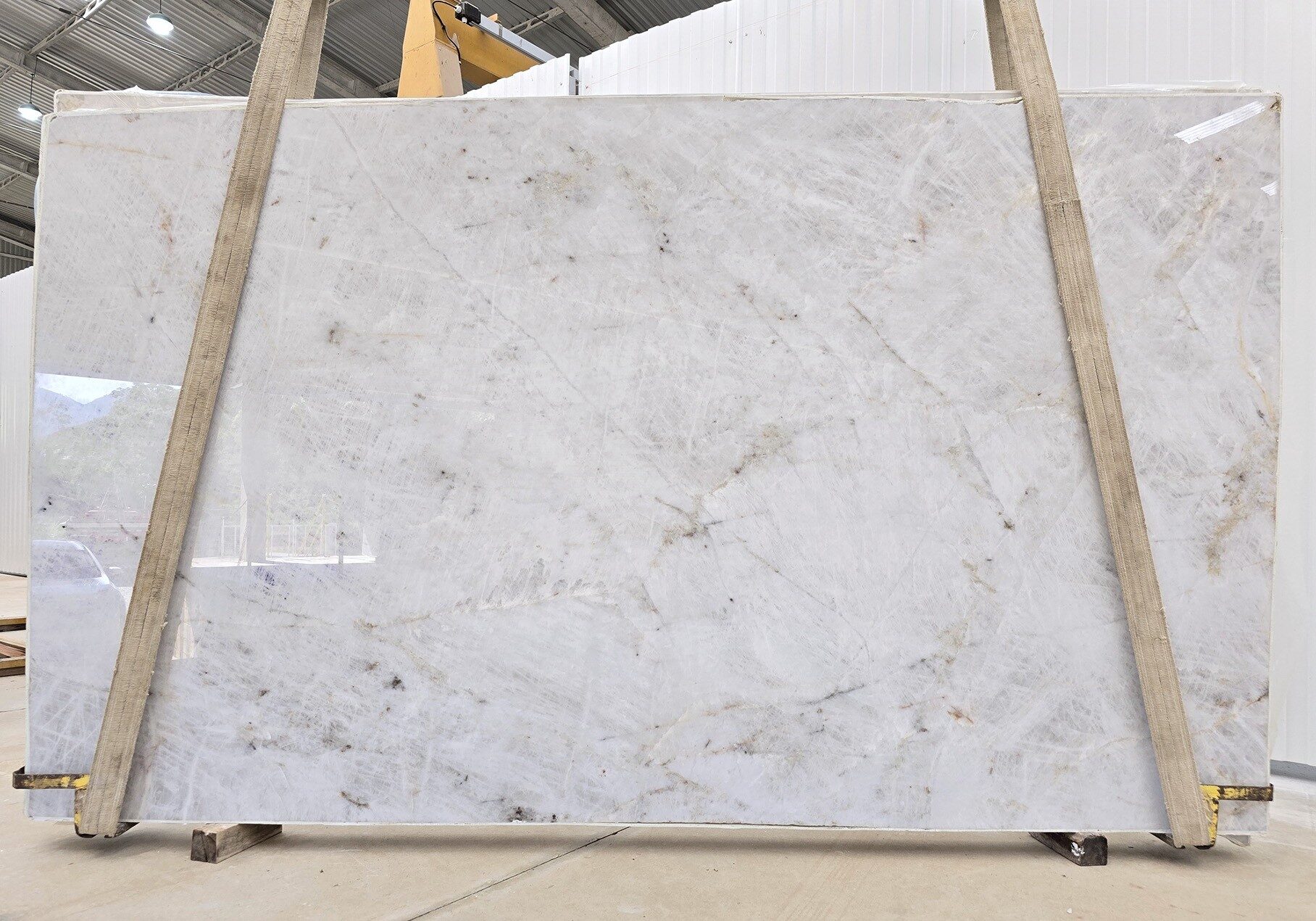 Large format slab with a luminous ivory background for luxury interior design.