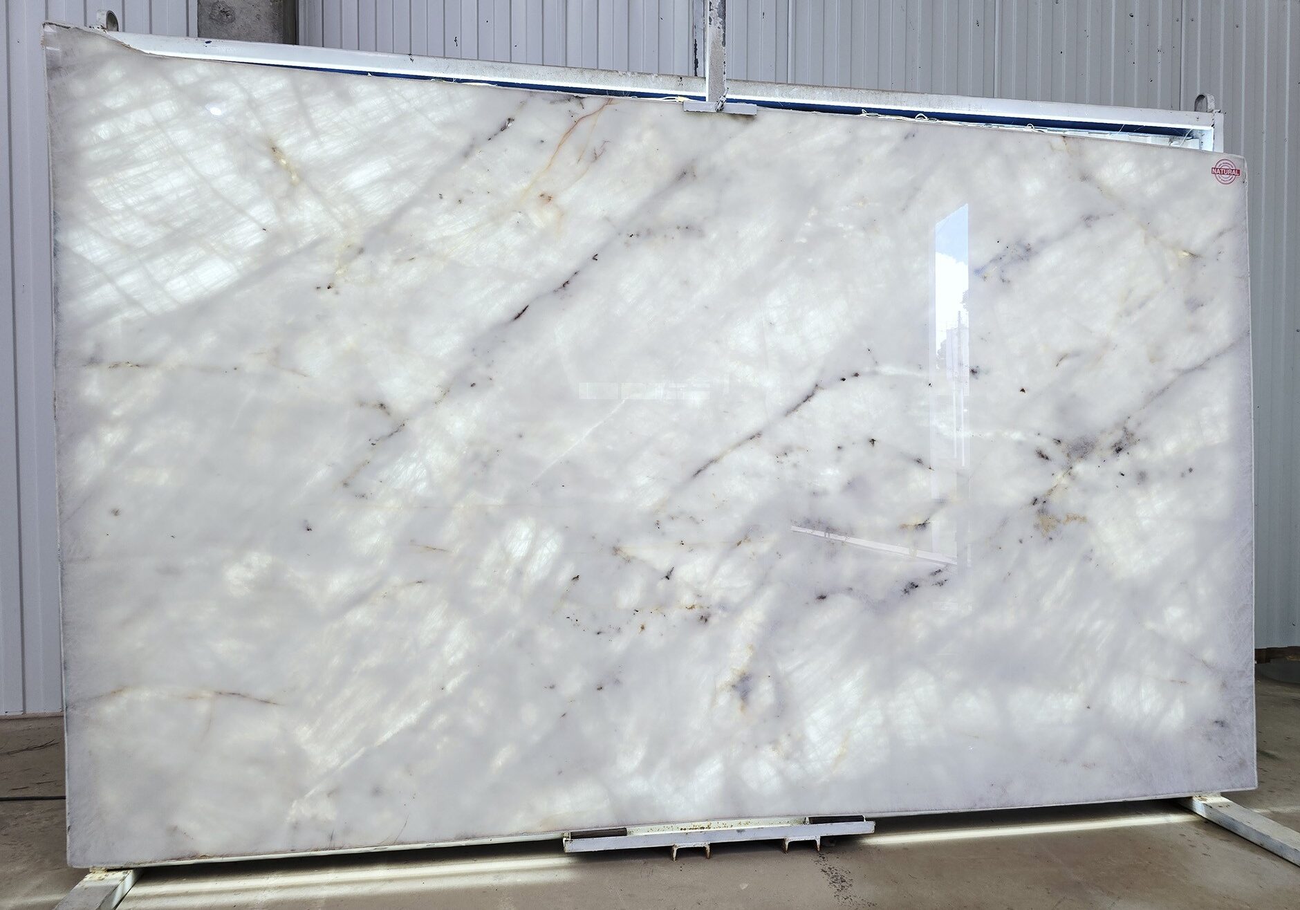 Dramatic view of a backlit slab highlighting its unique amber-toned crystalline structure.