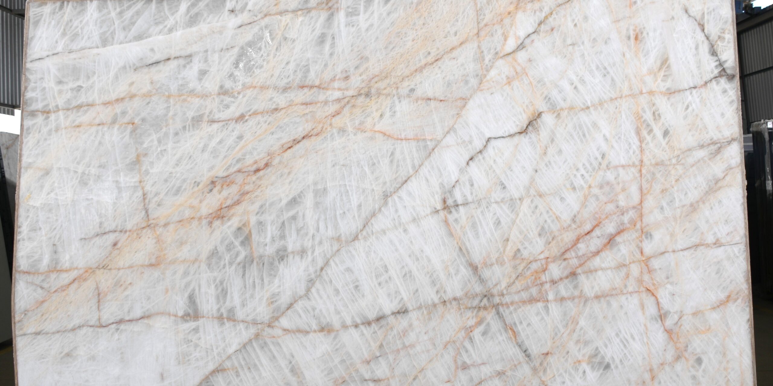 Large format slab showcasing the natural golden fractures and white background.
