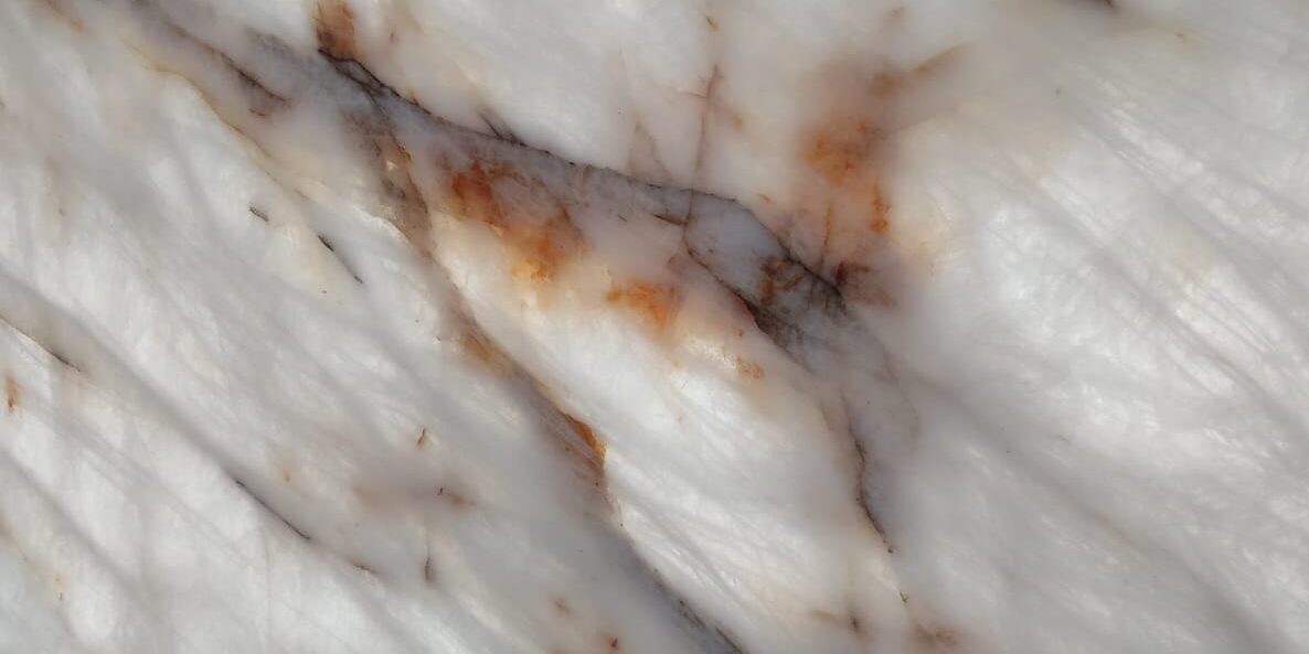 Extreme detail of the crystalline white structure and vibrant amber veins of Cristallo Gold Quartzite.