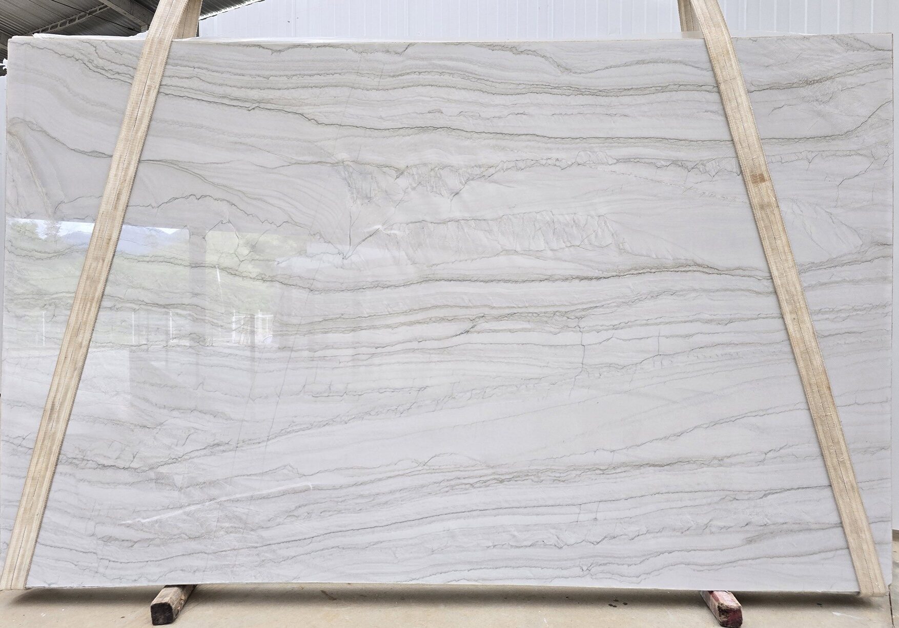 Full polished white stone slab with soft horizontal gray veining and layered natural patterns.