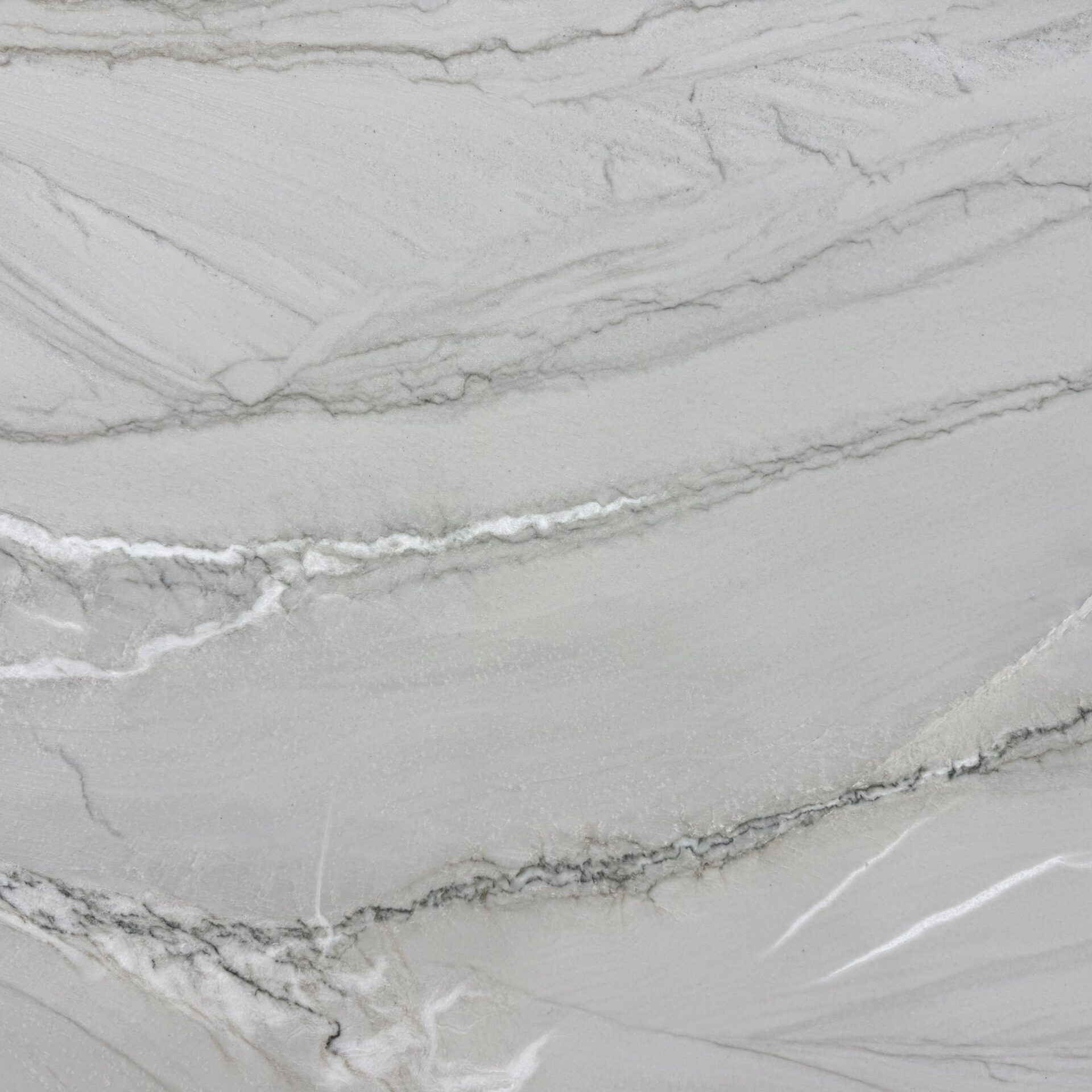Detailed shot of the soft blue and deep grey veining against a creamy white natural stone background.