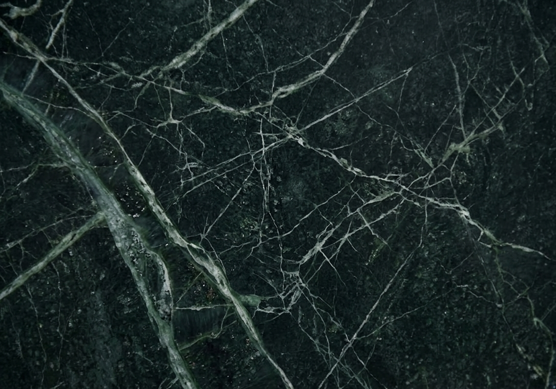 A detailed macro view of the deep emerald crystals and erratic slate veining of a premium Brazilian stone.