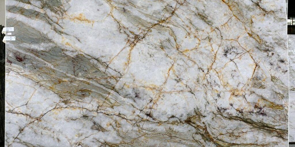 Detailed of translucent white quartzite with gold and green mineral veins.