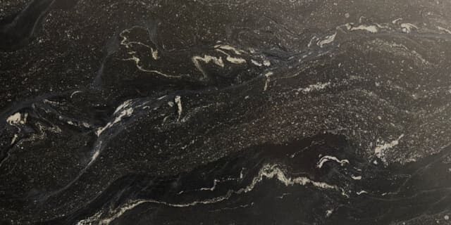 A detailed shot focusing on the tactile quality and glare-free face of a deep slate-colored leathered natural stone.