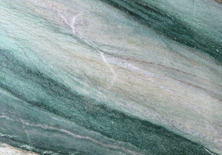Detailed close-up focusing on the rich, textured green fuchsite layers and earthy undertones of an exotic natural stone.