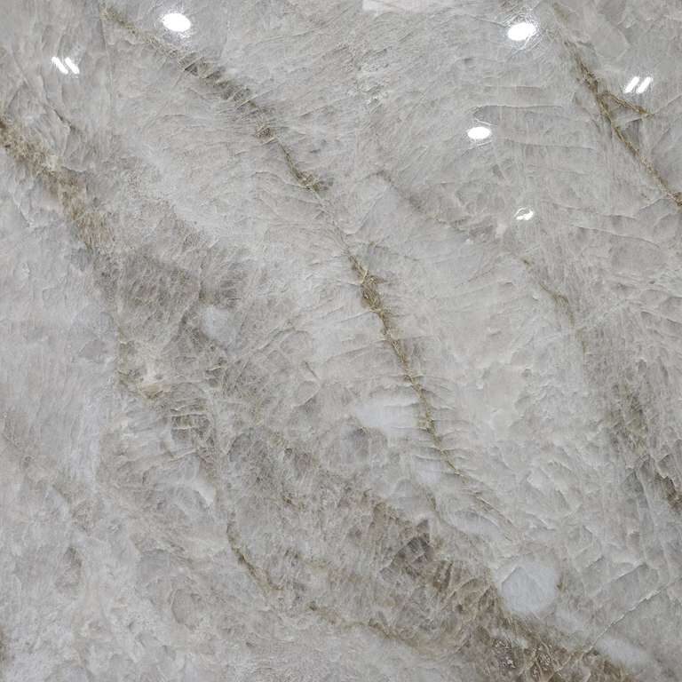 Detailed view of the polished finish and consistent ivory tones of a high-quality slab.