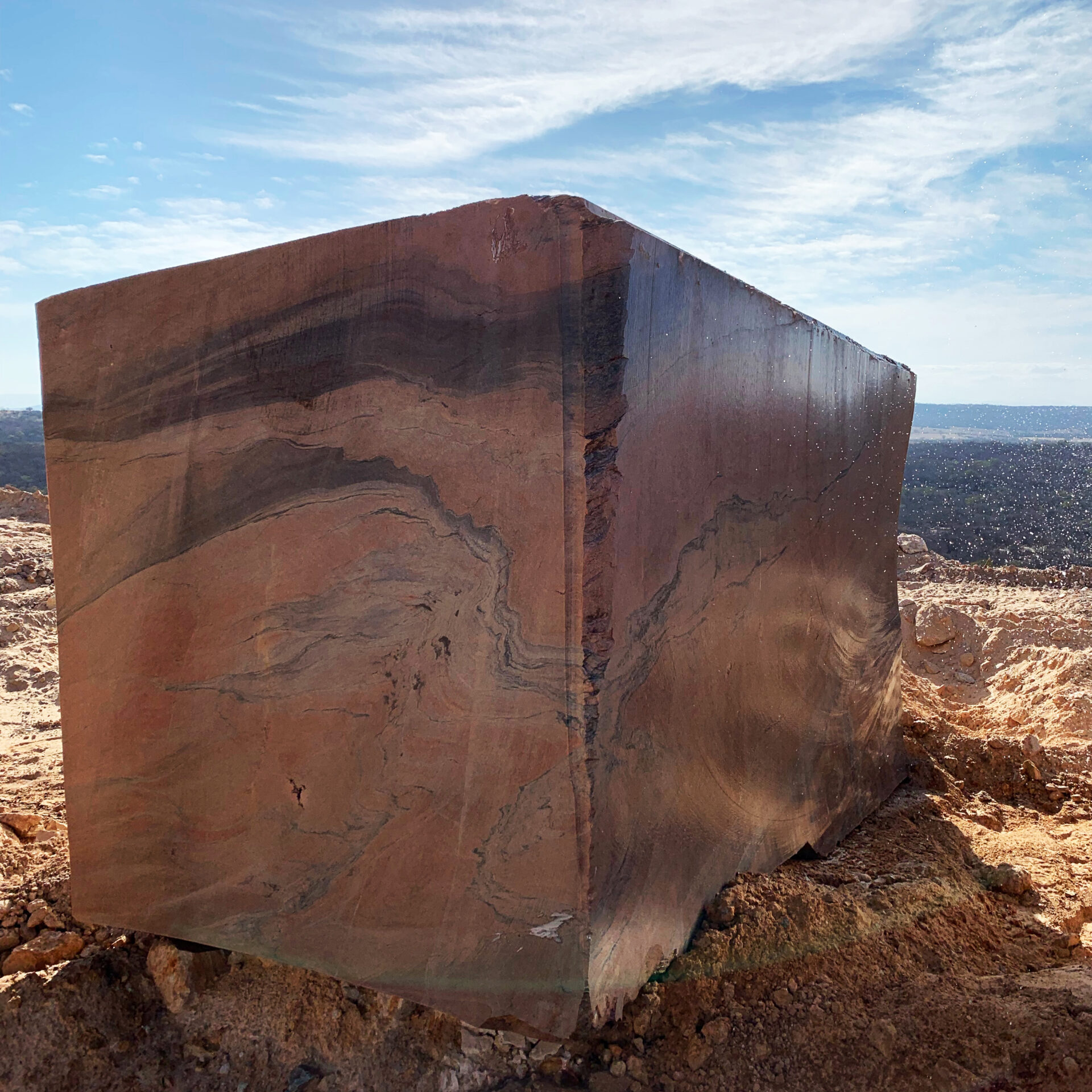 Extraction of premium natural stone blocks from a red quartzite quarry.