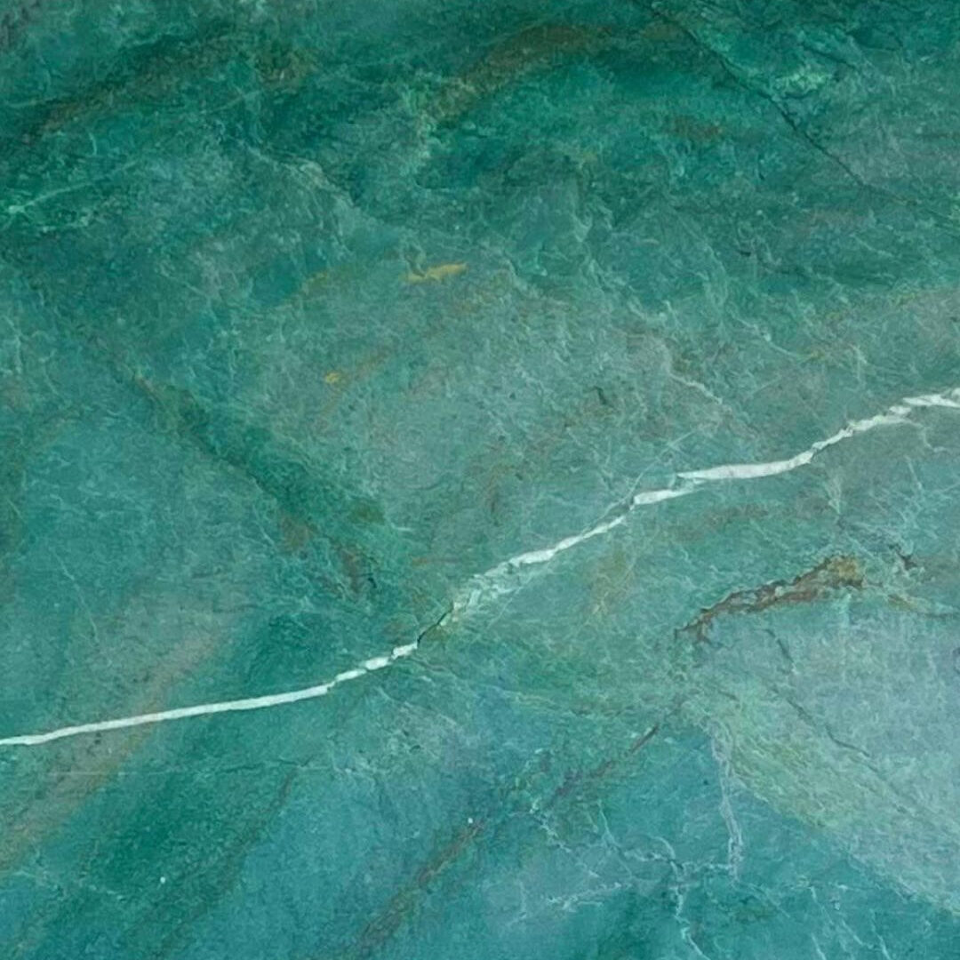 Close-up of sombori quartzite highlighting the deep emerald green minerals and translucent white crystal veins.