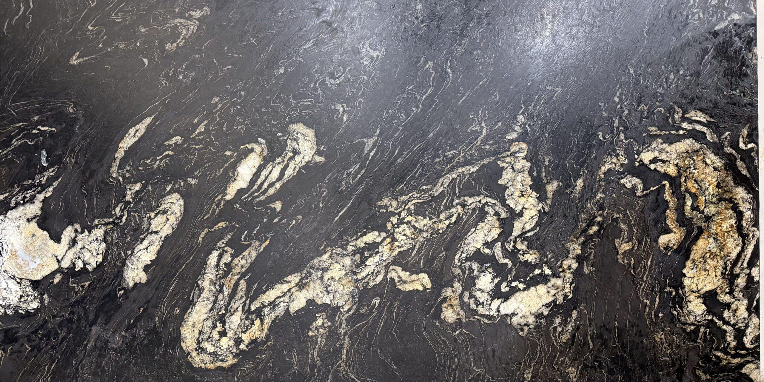 Detailed shot focusing on the intense texture of copper, ivory, and amber veins flowing across a dark natural stone surface.