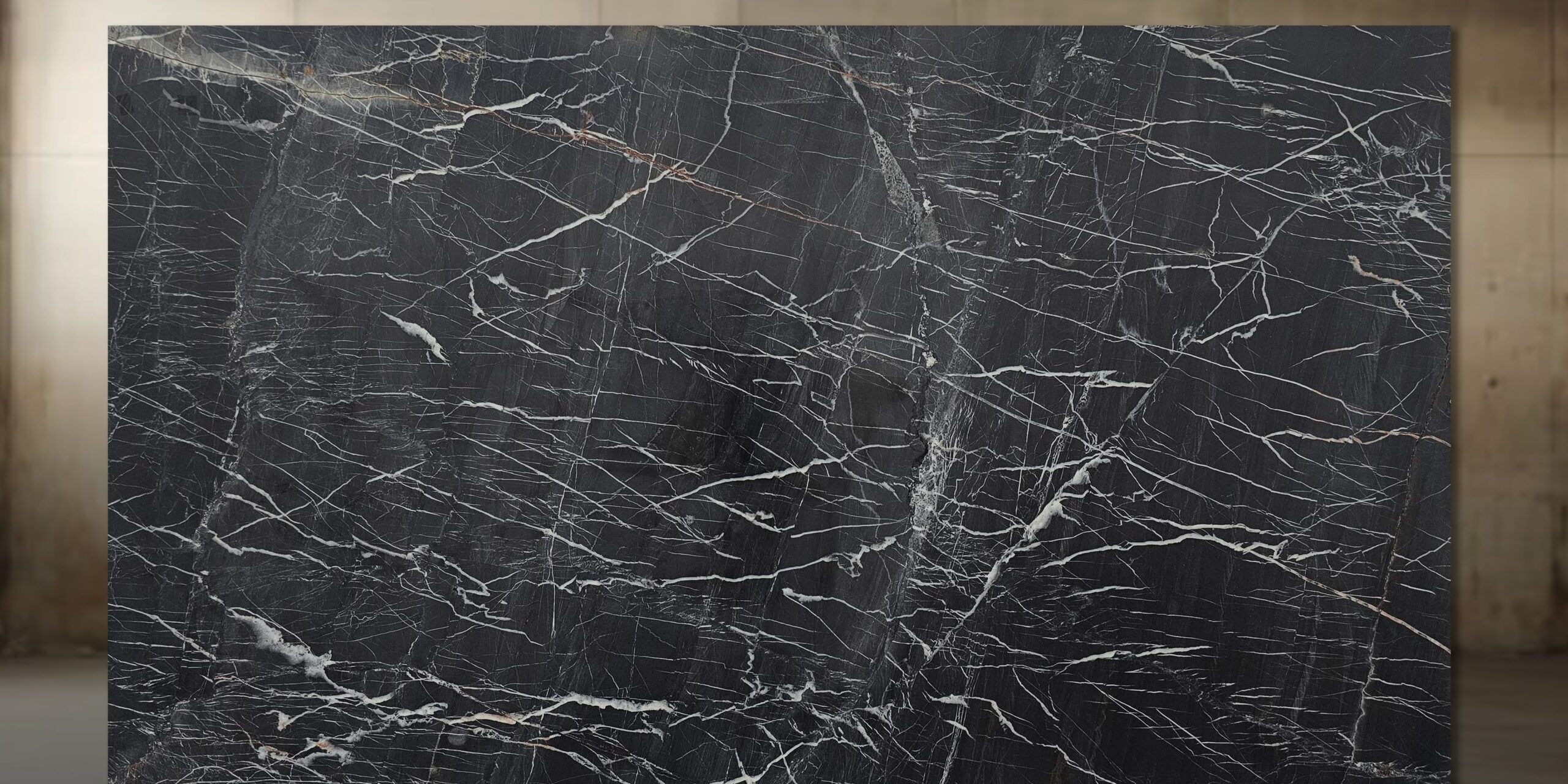 Wide view of a premium Venom Quartzite slab in our warehouse, showcasing the deep obsidian surface and sharp, geometric white veining.