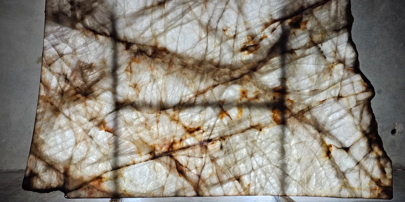 A large-format translucent stone slab with distinct gold accents, available at our quartzite store in Austin.