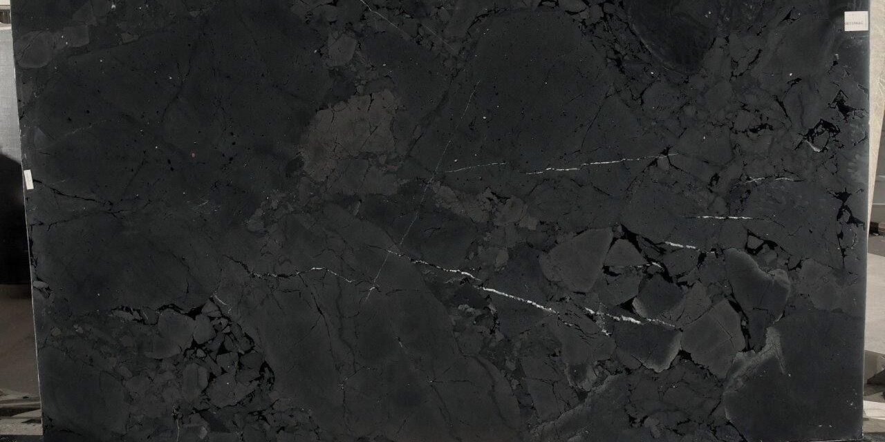 Large quartzite slab featuring a dramatic black surface with layered textures and fine contrasting veins.