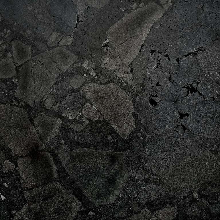Close-up of Black Diamond Quartzite showcasing its deep charcoal background with subtle white veining and natural fractured patterns.