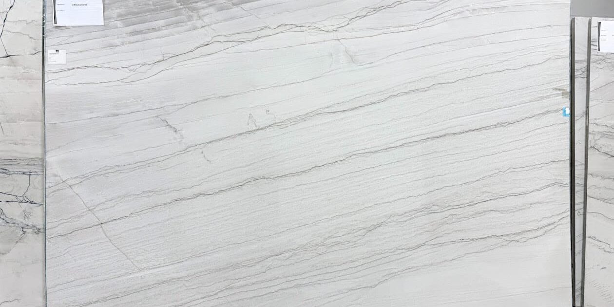 Full view of a White Santorini Quartzite slab showcasing its expansive snow-white background and gentle diagonal gray bands.