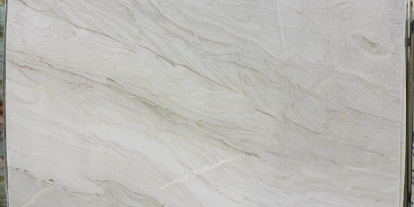 Full view of a polished white natural stone slab showcasing a balanced distribution of light and subtle gold veining.