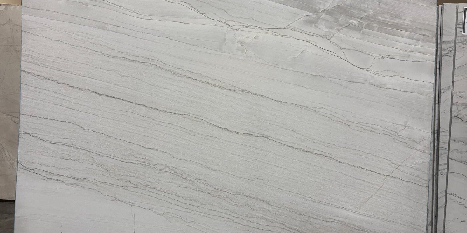 Full look at a premium white stone slab displaying consistent, tight linear veins from edge to edge.